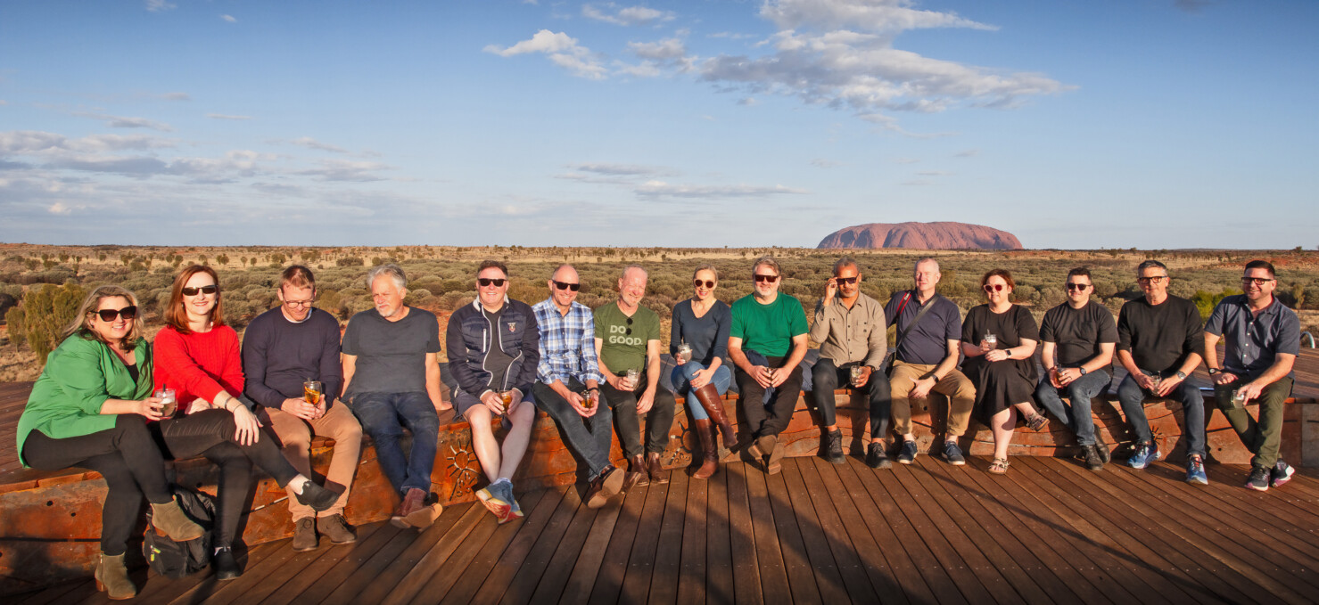 DesignInc directors from offices in Adelaide, Brisbane, Melbourne, Perth and Sydney met at Uluru this year in late July. Pictured from left to right in front of Uluru in late afternoon golden light; Mary Anne McGirr, Cathryn Drew-Bredin, Grant Hinds, Craig Kerslake, Cameron Martin, Richard Stafford, Richard Does, Di Lund, Darryl Suttie, Christon Batey-Smith, Rohan Wilson, Sonya Montgomerie, Ben Luppino, Ian Armstrong