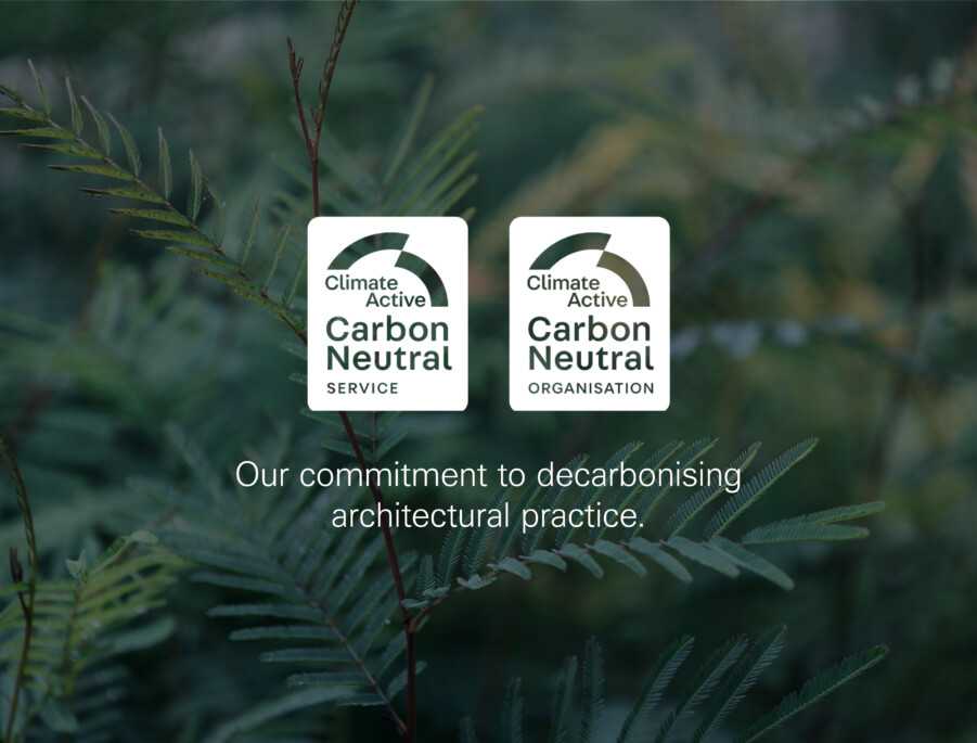 Dark green fern background with 2 logos that say Climate Active - Carbon Neutral Service and Climate Active - Carbon Neutral Organisation in white. White text below the logos reads Our committment to decarbonising architectural practice.